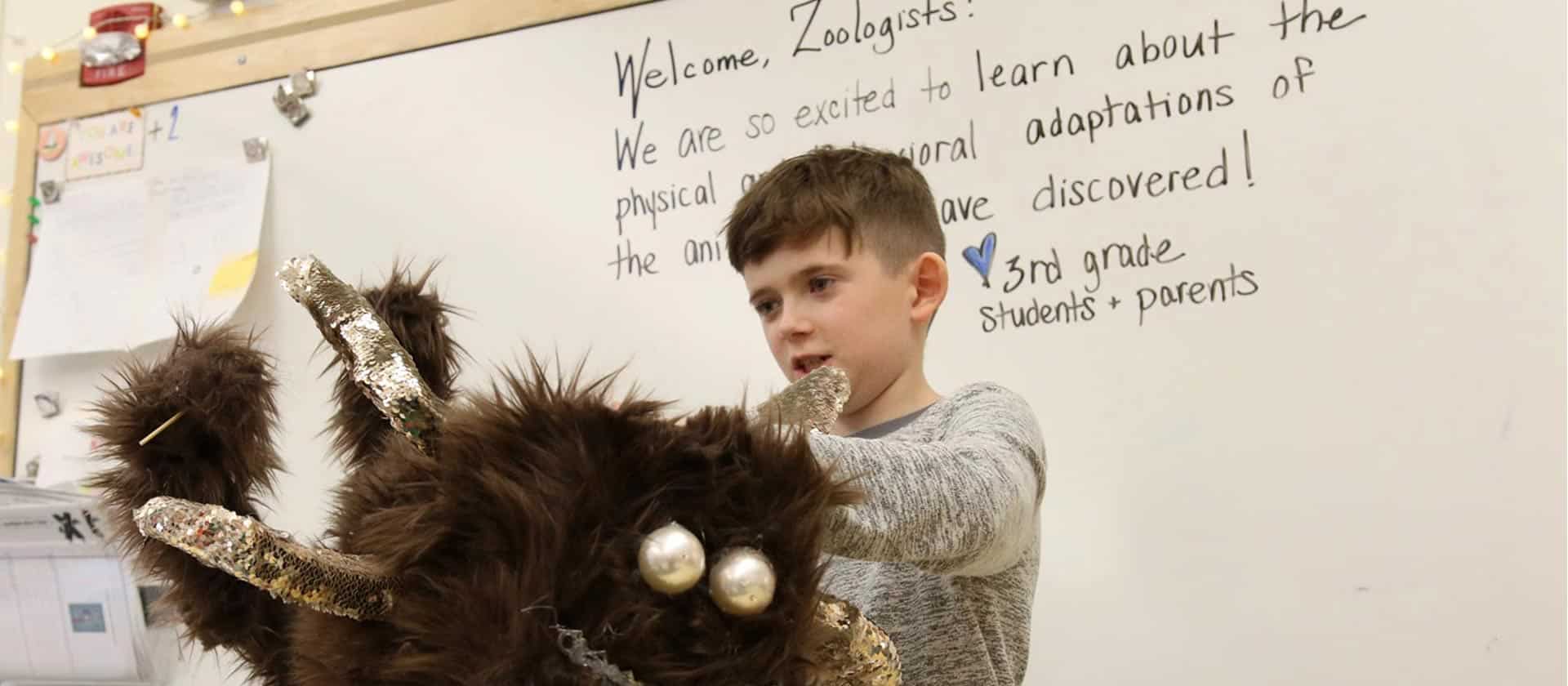 A student presents their animal adaptation project