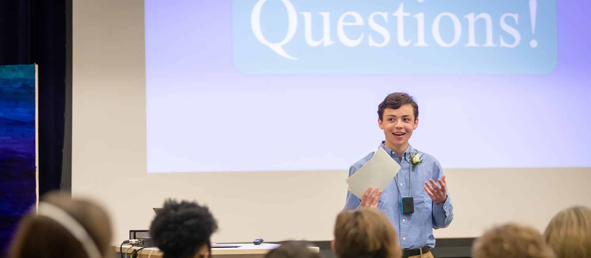 An eighth grader takes audience questions during a presentation