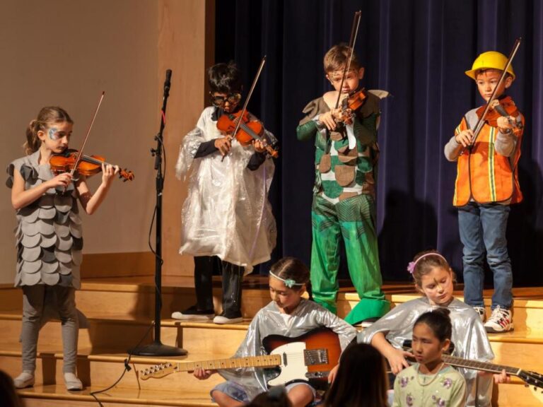 Students perform with violins and guitars