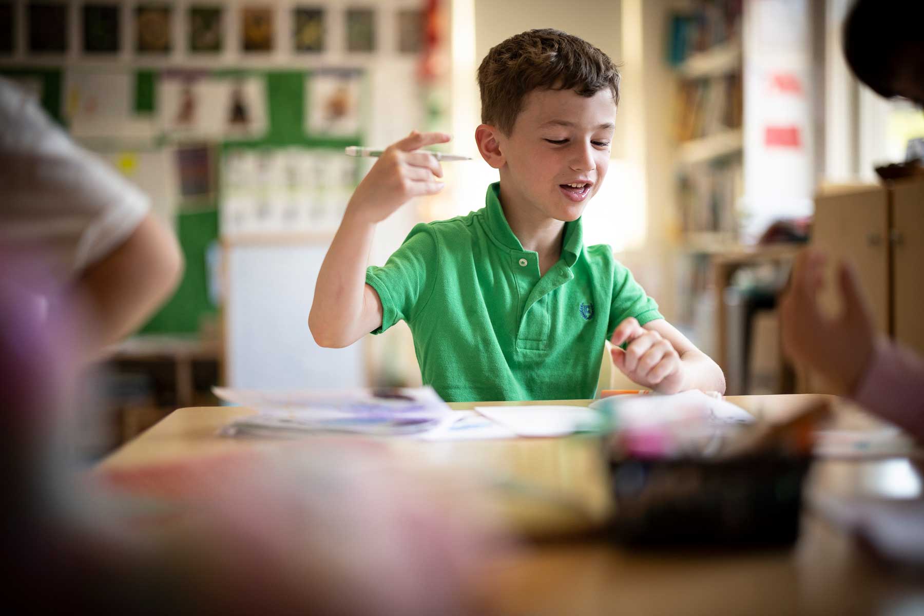 A student gestures with excitement in the classroom