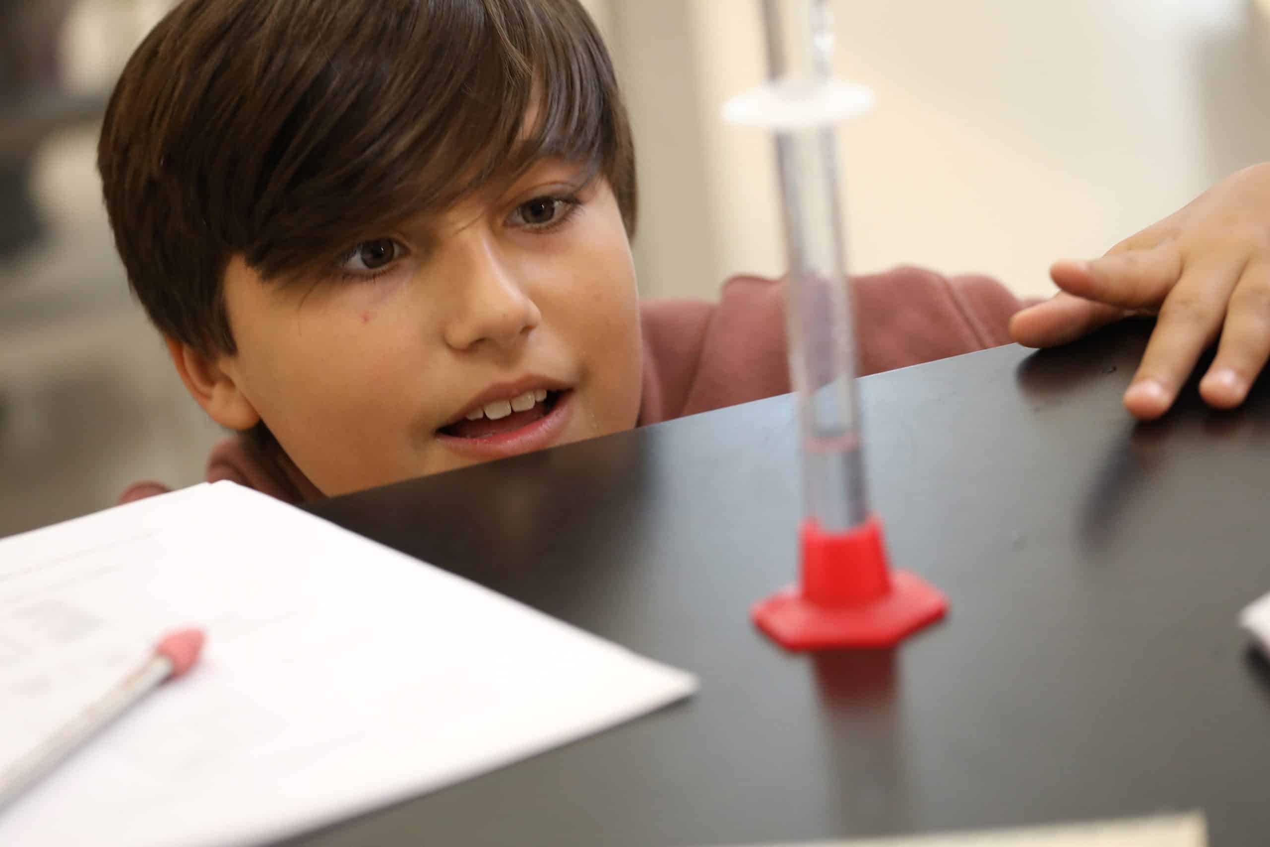 A sixth grader carefully observes the contents in a test tube