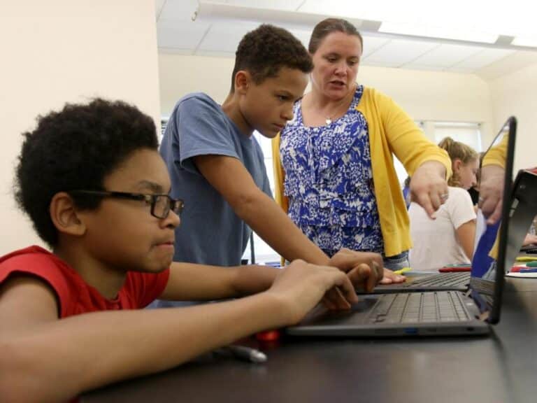 Two students work with a teacher