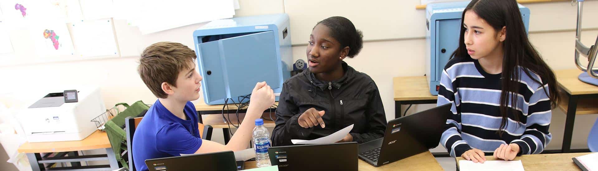 Three students discuss a project together