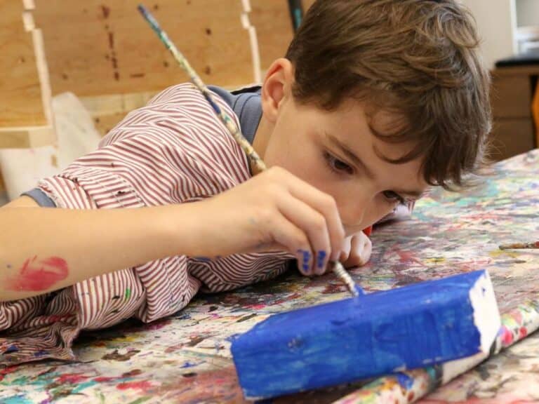 A boy paints in the studio