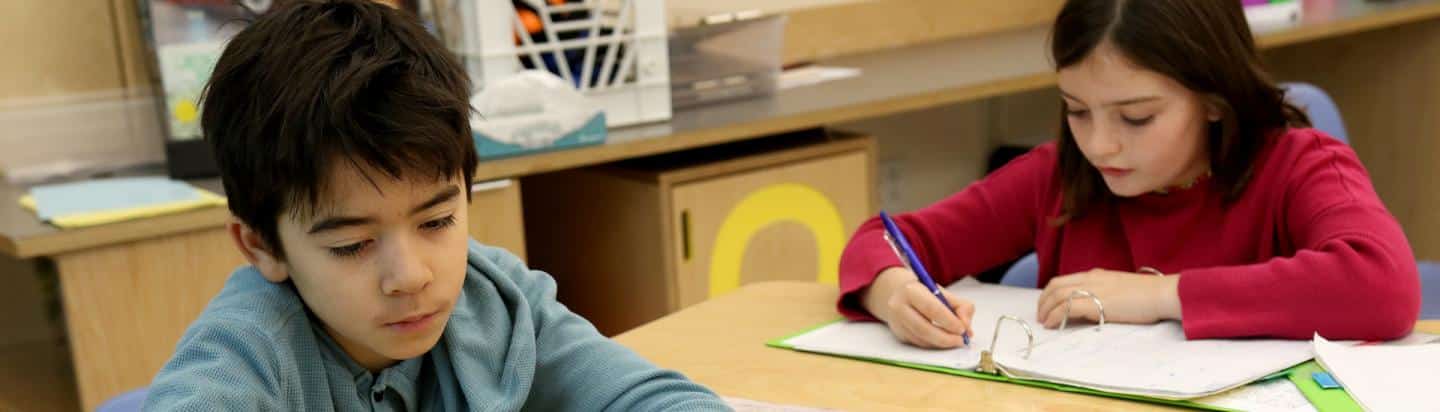 Two fourth grade students work together at their desks