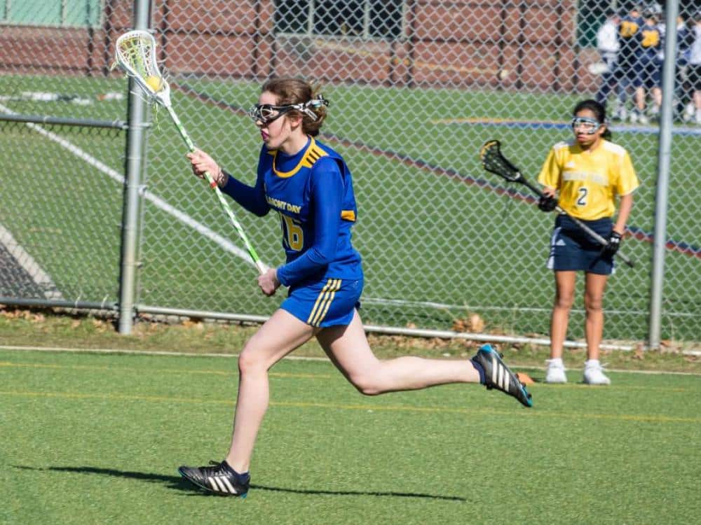 Girl lacrosse player running