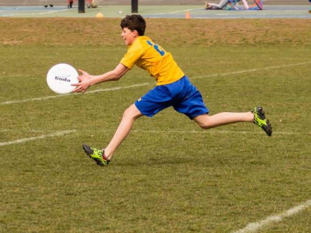 Boy running to catch a frisbee