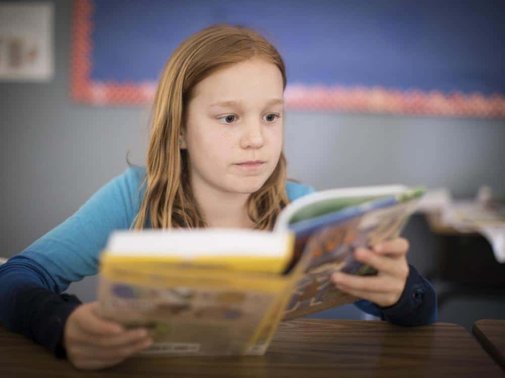 a student reading a textbook at Belmont Day School