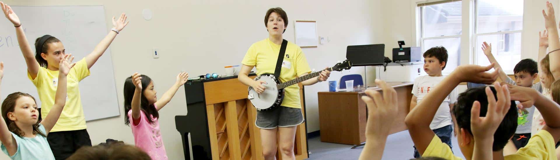 Two camp counselors lead a music class