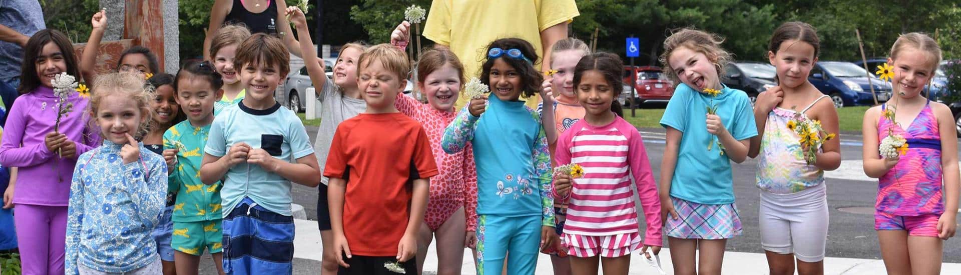 A group of summer campers holding flowers