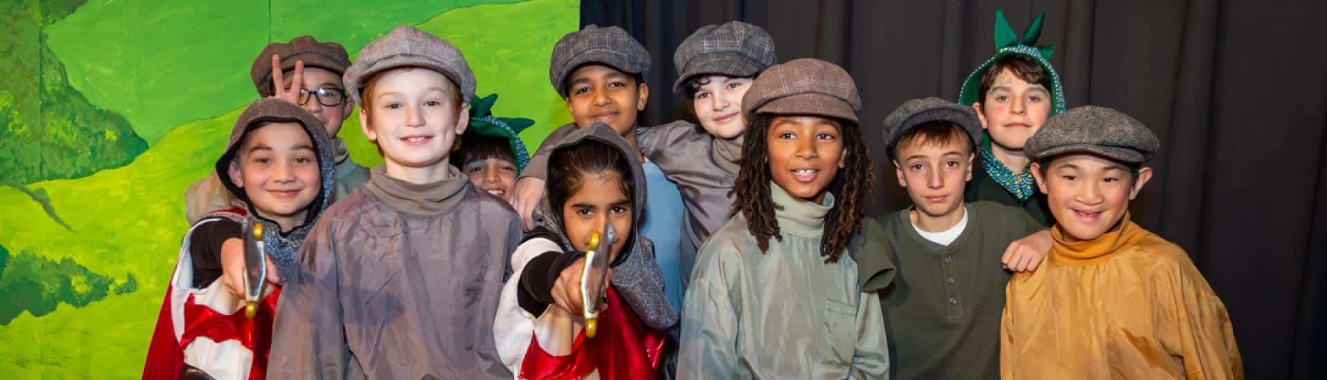 A group of boys in costume on stage during their class play