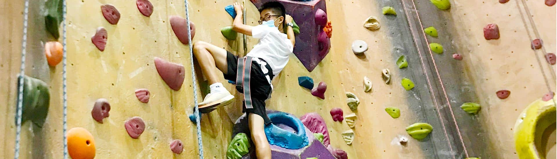 A camper takes on a climbing wall