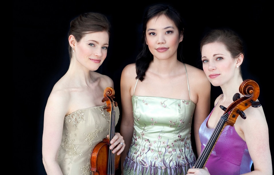 Emily Bruskin Yarbrough '92 (holding violin,) Andrea Lam, and Julia Bruskin Wunsch '92 (holding cello.)