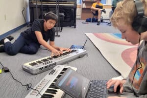 Two students work on a sound recording in an arts elective
