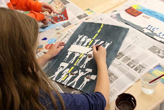 A fifth grader works on a Jacob Lawrence-inspired work