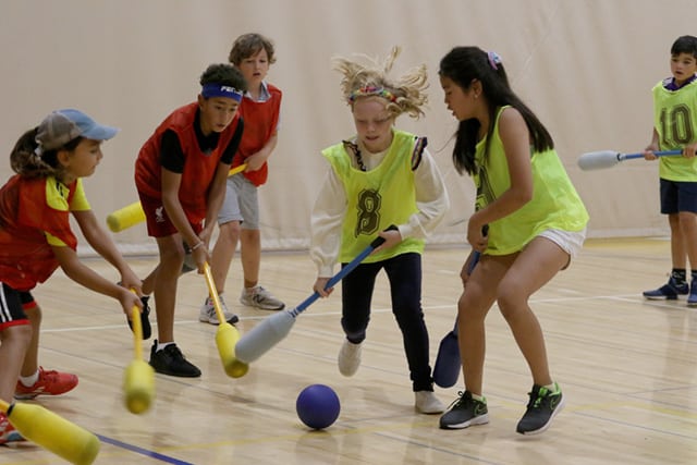 A group of fifth graders in a field hockey scrimmage