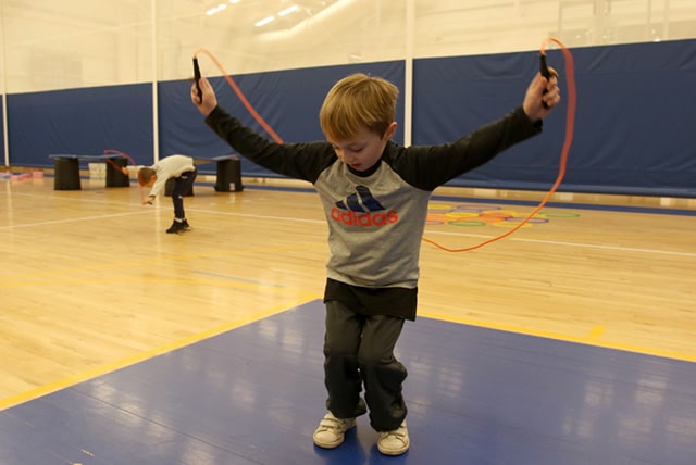A first grader practices jump rope skills