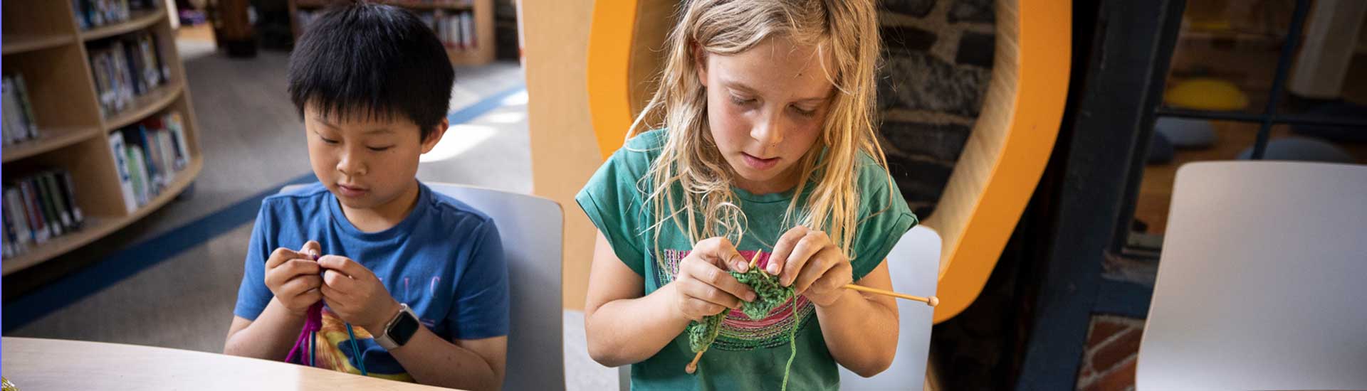 Two students knit together in the Erskine Library