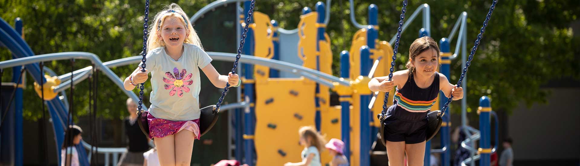 Two students swing together on the school playground