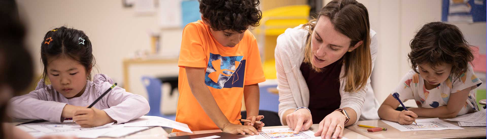 First grade teacher reviews work with three students