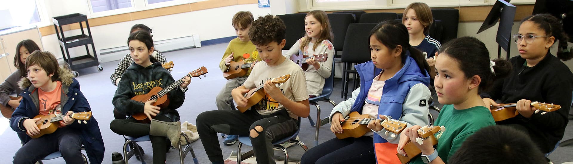 A fourth grade music class plays ukulele together