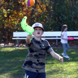 A boy outdoors playing scoop ball