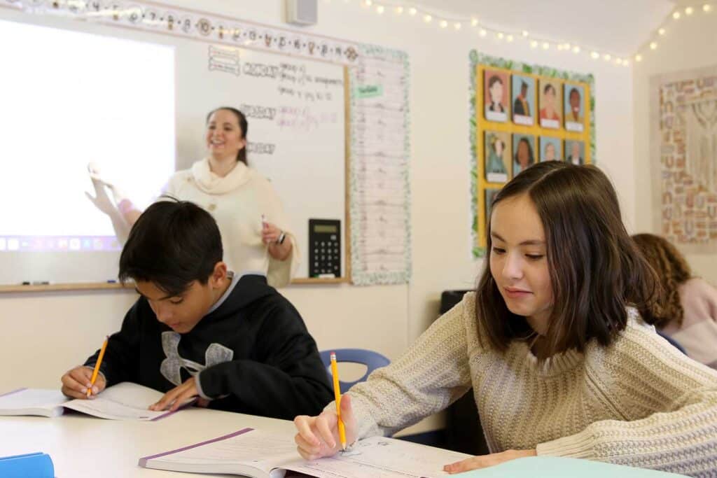 Math teacher Brittany Ryan at the white board with two students