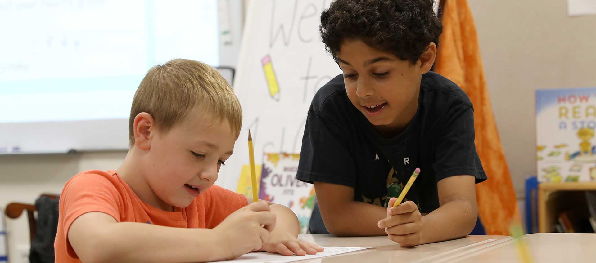 Two cross-graded partners work together at a desk and smile